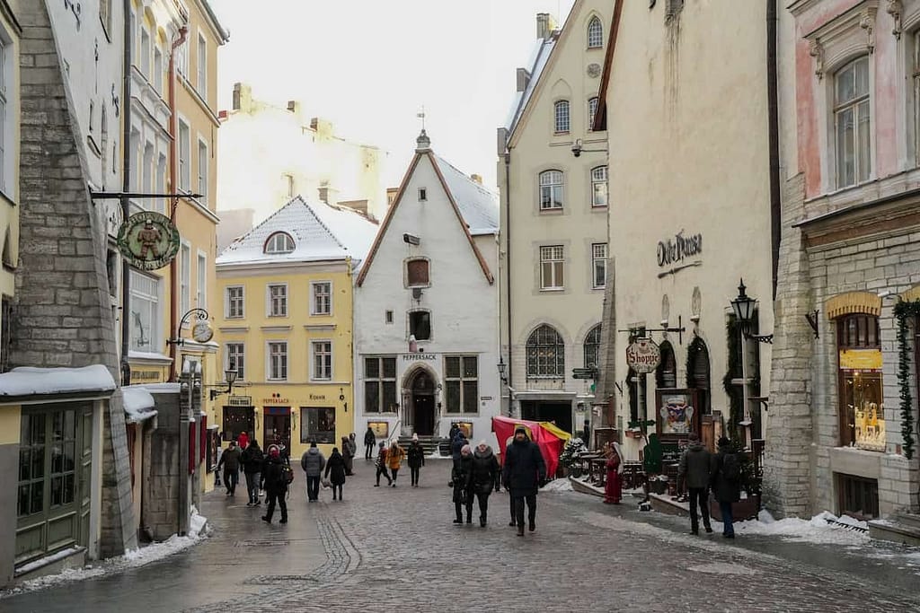 The busy, beautiful streets of Tallinn in winter in Estonia. People walk among the mostly preserved medieval buildings.