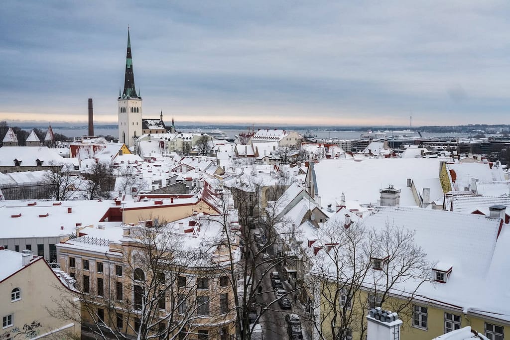 The skyline of Tallinn, Estonia, at dusk, overlooked by St. Olaf's Church. The Church's steeple dominates the skyline of the city.