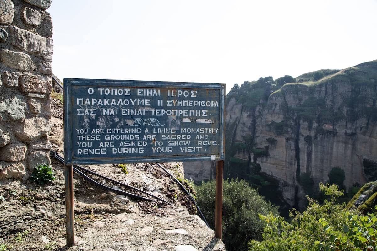 A sign reminding visitors to act respectfully on the holy ground of Meteora.