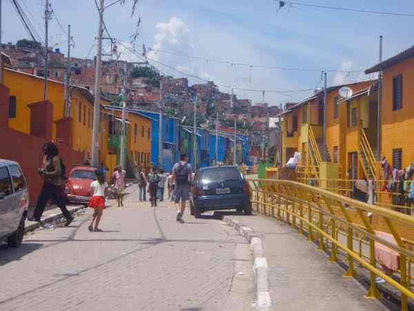 The favela's main entrance, with colorful houses lining the street.