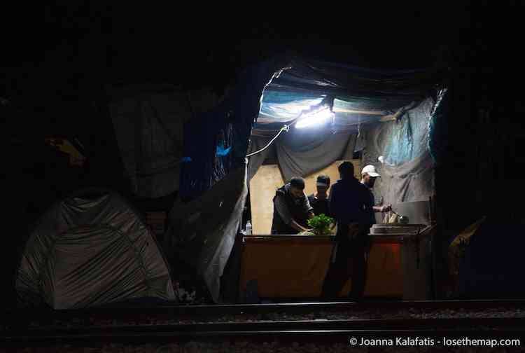 A food stall run by refugees stays open late.