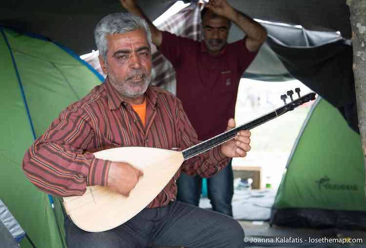 A musician continues playing day and night while his friends dance in the refugee camp.