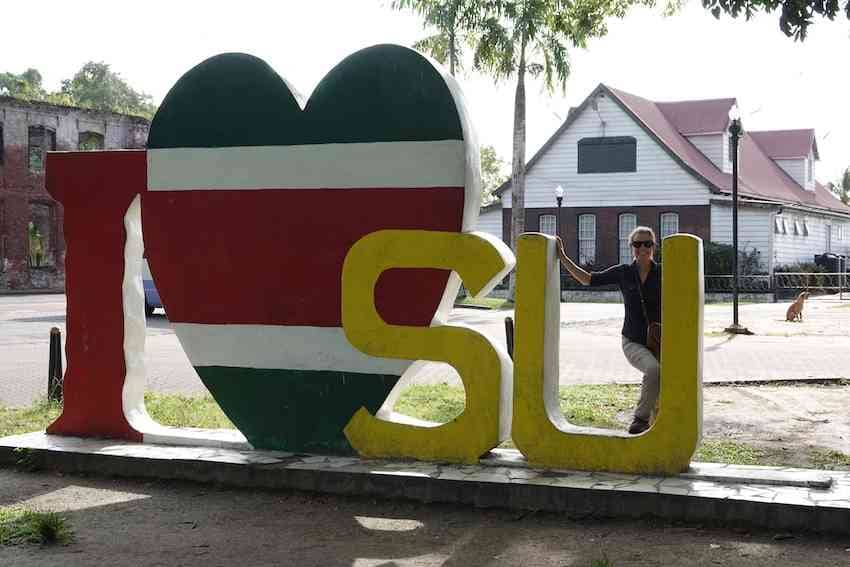 Janice in Suriname next to a sign